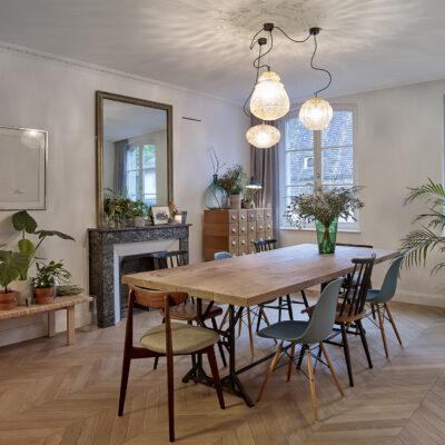 salle à manger avec grand lustre et table en bois